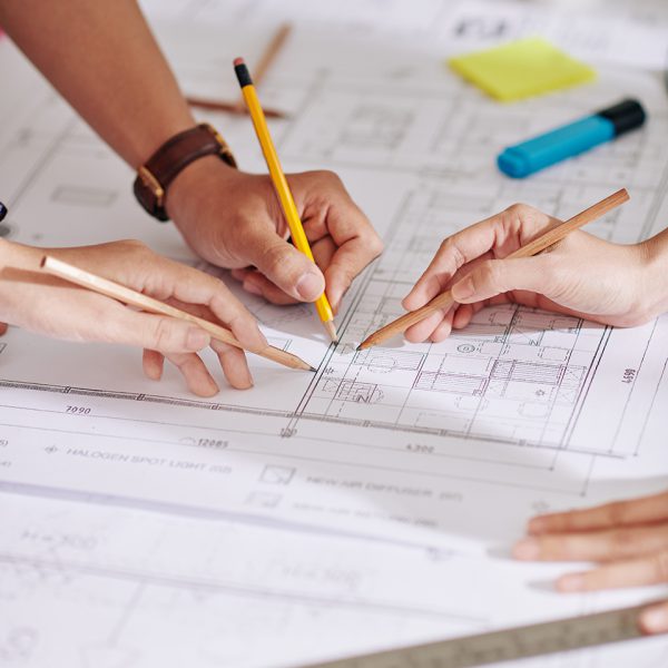 Hands of construction engineers discussing detail of construction plan at meeting